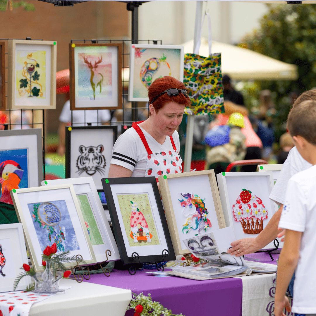 woman selling paintings at the Ashland Strawberry Faire